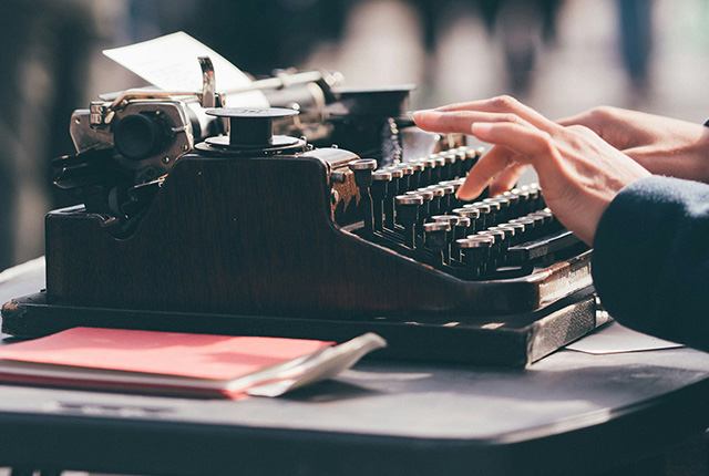 A person typing on a typewriter